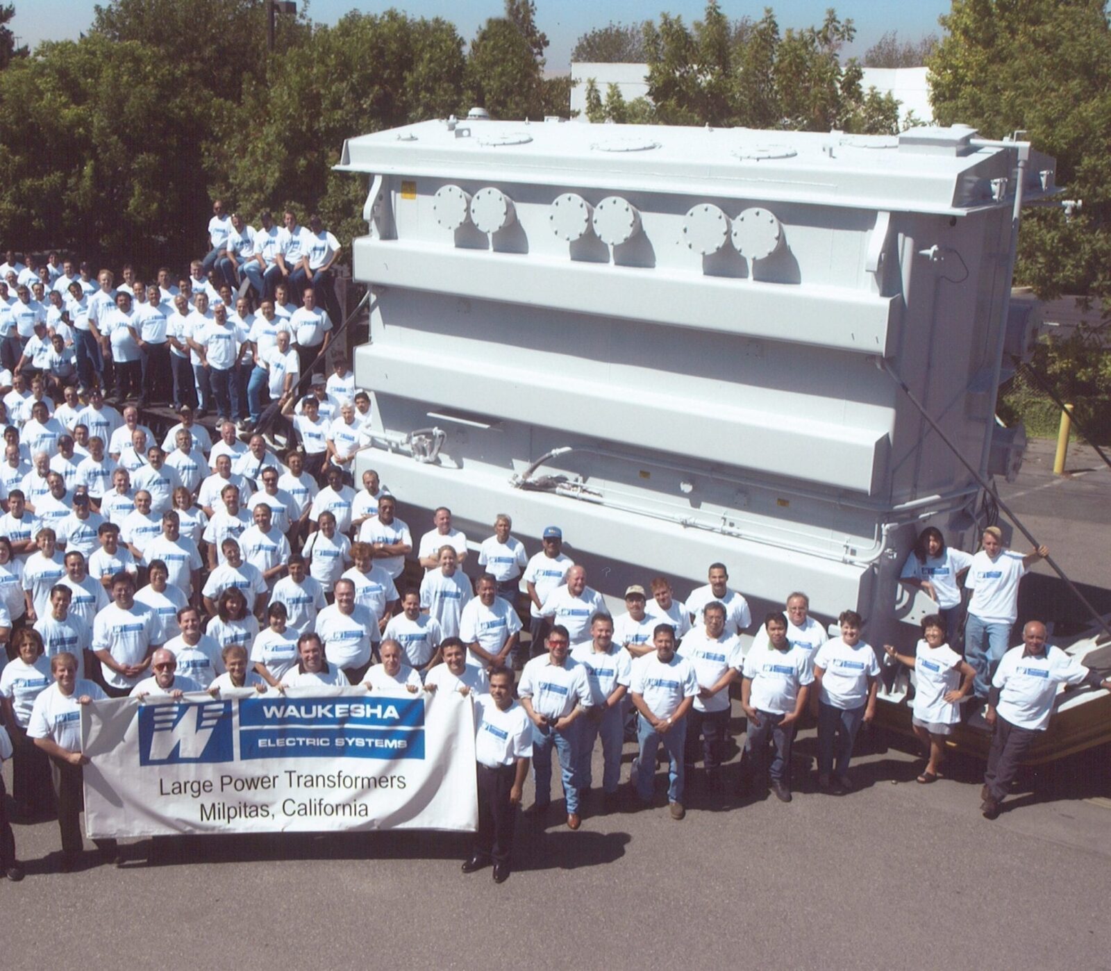Milptas employees in front of a transformer